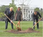  ?? JIM WATSON/AFP/GETTY IMAGES ?? Donald Trump and Emmanuel Macron plant a tree.