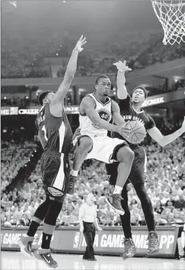  ?? Thearon W. Henderson Getty Images ?? GOLDEN STATE’S Harrison Barnes finds space between New Orleans’ Tyreke Evans (1) and Anthony Davis to get a shot up during the first quarter.