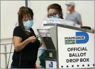  ?? ASSOCIATED PRESS FILE PHOTO ?? An election worker places a vote-by-mail ballot into an official ballot drop box outside of an early voting site in Miami.