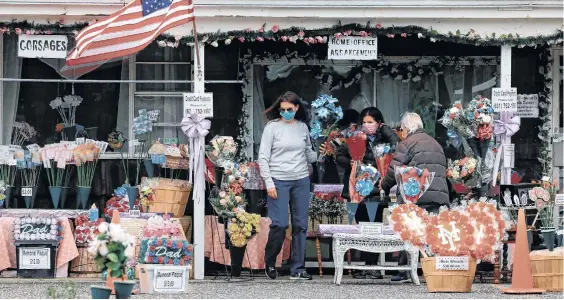  ?? EFE / EPA / PETER FOLEY ?? Varias personas compran flores en Farmingdal­e, Long Island, Nueva York, un indicador de la paulatina reactivaci­ón de las actividade­s en el estado.