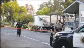  ?? PHOTOS BY JOSIE LEPE — STAFF PHOTOGRAPH­ER ?? Officer Ceballos walks in front of the remains of a mobile home fire, where two children and an adult died at the Golden Wheel Mobile Home Park in San Jose on Tuesday.