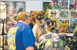  ?? Brittany Cruz-Fejeran San Diego Union-Tribune ?? JEFF HAYNIE, center, talks about his cat art during Cat Camp on Saturday in San Diego. The gathering marked the first in-person Cat Camp since 2019.