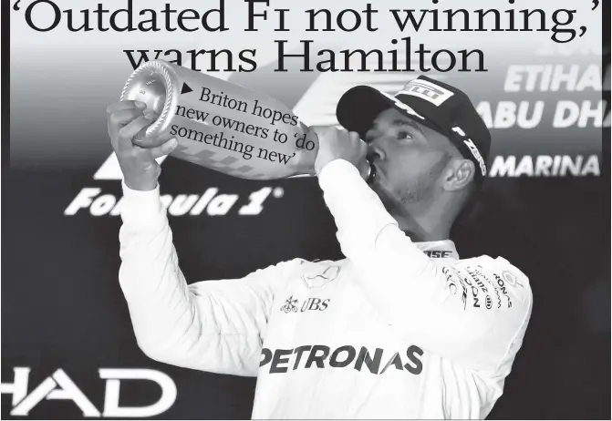  ?? Photo: CFP ?? Mercedes driver Lewis Hamilton celebrates on the podium after winning the Abu Dhabi Formula One Grand Prix on November 27, 2016.