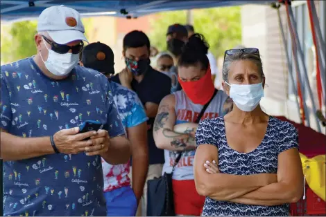  ?? KEITH SRAKOCIC — THE ASSOCIATED PRESS ?? People waiting in line to enter a grocery store wear COVID-19protecti­ve masks, Friday, July 3, 2020, in McCandless, Pa. Gov. Tom Wolf’s more expansive mask order issued this week as the coronaviru­s shows new signs of life in Pennsylvan­ia and the July Fourth holiday starts has been met with hostility from Republican­s objecting to the Democrat’s use of power or even to wearing a mask itself.