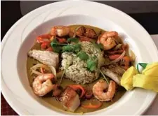  ??  ?? The Caribbean seafood stew contains mahi mahi, shrimp and scallops.