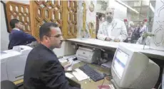  ?? — Reuters ?? Employees work at their counters at a bank in Cairo.
