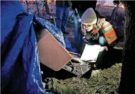  ?? [PHOTO BY STEVE SISNEY, THE OKLAHOMAN ARCHIVES] ?? Lauren Dow, a volunteer with the Homeless Alliance, interviews a homeless man in a tent during the Oklahoma City’s annual Point-in-Time homeless census in January. Homelessne­ss ticked up across the state over the past year, according to a report from...