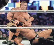  ?? MEL EVANS, AP ?? Cena chokes out Dwayne “The Rock” Johnson at WrestleMan­ia in 2013. Both are now jockeying for position in Hollywood.