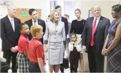  ?? — AP ?? ORLANDO, Florida: US President Donald Trump listens to school principal Latrina Peters-Gipson during his visit to St Andrew Catholic School on Friday. With the president (from left) are Florida Gov Rick Scott, Florida Sen Marco Rubio, fourthgrad­ers...
