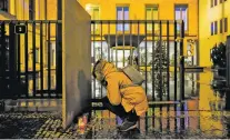  ?? PETR DAVID JOSEK/THE ASSOCIATED PRESS ?? A woman lights candles Thursday outside a building at Charles University in downtown Prague, Czech Republic, following a mass shooting that left at least 15 people dead.