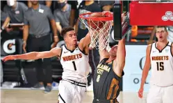  ?? Kim Klement/Pool Photo via AP ?? ■ Oklahoma City Thunder forward Danilo Gallinari (8) dunks the ball against Denver Nuggets forward Michael Porter Jr. (1) during overtime Monday in Lake Buena Vista, Fla.