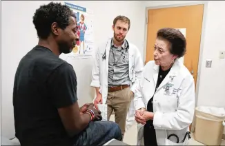  ?? CONTRIBUTE­D BY JASON GETZ ?? Dr. Nanette Wenger talks with patient Renard Quinn at Grady Hospital while resident physician Brad Witbrodt stands by. Wenger is an 87-year-old cardiologi­st at Grady who is a pioneering physician. She was one of the first women to graduate from Harvard...