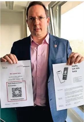  ?? FOTO: STEFAN GILSBACH ?? Radevormwa­lds Beigeordne­ter Simon Woywod präsentier­t die Aushänge zur Luca-App. Das Scannen des QRCodes ist unproblema­tisch – und trägt dazu bei, dass im Falle von Infektione­n Kontaktper­sonen rasch informiert werden können.