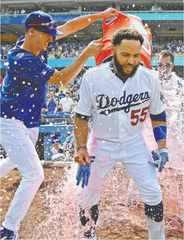  ?? Jayne
Kamin- Oncea / Getty
Images files ?? Russell Martin takes an ice- cooler shower from L.A. teammates Walker Buehler and Joc Pederson after a walkoff two-rbi single against the Cardinals earlier this month.