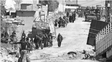  ??  ?? Displaced Iraqis from Mosul’s Matahen neighbourh­ood leave their homes as Iraqi counter-terrorism service (CTS) forces advance in the area during the ongoing offensive to retake the city from Islamic State group jihadists. — AFP photo