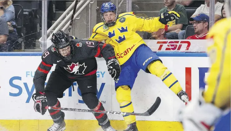  ?? CODIE McLACHLAN/THE CANADIAN PRESS ?? Canada’s Samuel Poulin collides with Sweden’s Karl Henriksson during Hlinka Gretzky Cup action in Edmonton on Wednesday. Canada won 4-3.