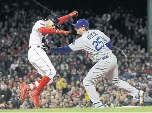  ?? DAVID J. PHILLIP THE ASSOCIATED PRESS ?? The Dodgers’ David Freese tags out Boston base-runner Mookie Betts during Game 2 of the World Series on Wednesday night at Fenway Park. Game 3 goes Friday night in Los Angeles.