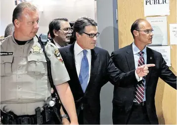  ?? Tom Reel / San Antonio Express-News ?? Gov. Rick Perry goes through the process of being booked on felony charges Tuesday in Travis County.