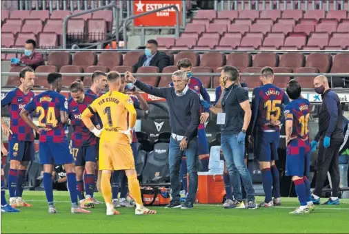  ??  ?? El técnico Quique Setién dialoga con sus jugadores durante una pausa de hidratació­n en uno de los partidos de LaLiga post confinamie­nto.