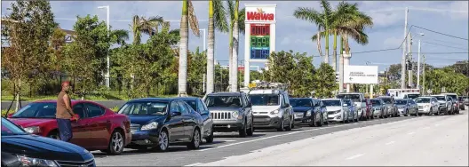  ?? LANNIS WATERS / THE PALM BEACH POST ?? Cars are backed up Tuesday at the Wawa station on Belvedere Road in West Palm Beach. Outages, return of evacuees, closed ports add to strain at pump.