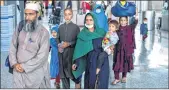  ?? - AP ?? Families evacuated from Kabul walk to board a bus after they arrived at Washington Dulles Internatio­nal Airport on Friday.