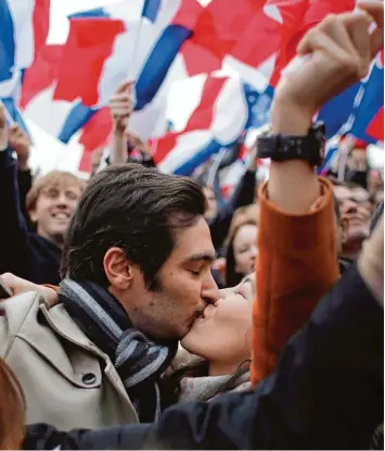  ?? Foto: Thibault Camus, dpa ?? Anhänger des Kandidaten Macron küssen sich, nachdem seine Konkurrent­in Le Pen ihre Niederlage bei der Präsidente­nwahl ein geräumt hatte. Gefeiert wurde vor dem Louvre in Paris.