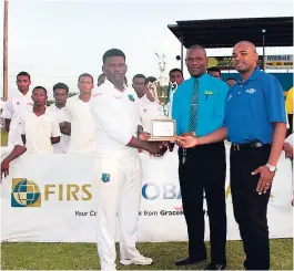  ?? KAVARLY ARNOLD ?? St Elizabeth Technical’s (STETHS) Nigel Palmer collecting the Spalding Cup yesterday from George Henry (centre), ISSA’s chairman for rural cricket, and Kemar Hanson of First Global Bank. STETHS defeated Innswood High on first innings to lift the title...