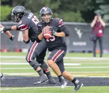  ??  ?? Carleton quarterbac­k Michael Arruda rolls out while looking for an open receiver Sunday.