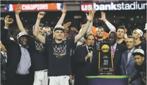  ?? DAVID J. PHILLI/ASSOCIATED PRESS ?? Virginia players celebrate with the championsh­ip trophy after defeating Texas Tech, 85-77, in the championsh­ip of the Final Four on Monday in Minneapoli­s.