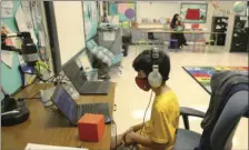  ?? VIA AP
SEMILY MICHOT/MIAMI HERALD ?? Nova Blanche Forman Elementary School teacher Attiya Batool, teaches her 4th grade class virtually as her son, Nabeel, does his second grade classwork online wearing a face mask and headphones during the first day of school in Broward, Wednesday, in Davie, Fla.