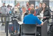  ??  ?? Travelers wear masks as they make their way through a security line Thursday at Denver Internatio­nal Airport.