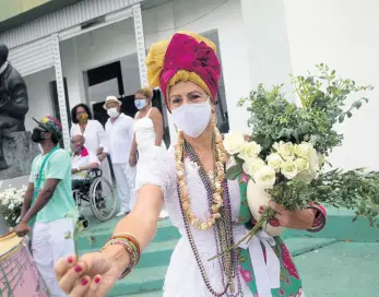  ??  ?? A samba school member offers herbs during a ceremony marking the symbolic start of Carnival at the Samba Museum during the COVID-19 pandemic in Rio de Janeiro, Brazil, yesterday. The school performed a cleansing ceremony at a time that normally would be the start of four days of parades and parties, but this year Carnival will mostly take place online after city officials cancelled festivitie­s due to the pandemic.