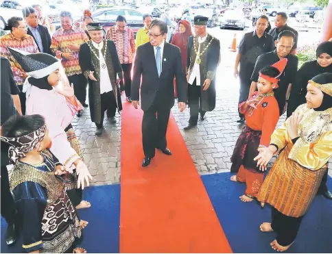  ??  ?? Abang Johari is welcomed during his arrival at Stadium Perpaduan to launch the 29th Kuching City Day celebratio­n by Chan (left) and Abang Abdul Wahap (right). — Photo by Kong Jun Liung