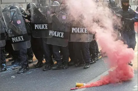  ?? Sakchai Lalit/Associated Press ?? Smoke rises from smoke bombs thrown by members of We Volunteer, a network of Thai pro-democracy protest security guards, who joined Myanmar protesters in Bangkok on Monday. Myanmar's military has taken control of the country under a one-year state of emergency and reports say State Counsellor Aung San Suu Kyi and other leaders have been detained.