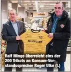  ??  ?? Ralf Minge überreicht eins der 200 Trikots an Konsum-Vorstandss­precher Roger Ulke (l.)