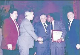  ??  ?? Henry Glover, fourth from left, receives award and a handshake from a former New York police lieutenant and father of a slain o cer.