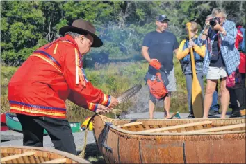  ?? LAWRENCE POWELL ?? Canoe builder Todd Labrador smudges the two new canoes he built at Keji this past summer.