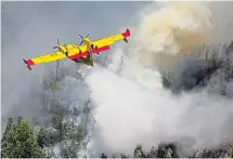  ??  ?? A firefighti­ng aircraft drops water on the blaze yesterday