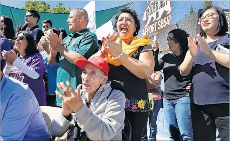  ?? Mel Melcon Los Angeles Times ?? MARTA SAMANO, third from right, cheers during a news conference Thursday at Academia Avance Charter school in Highland Park. The community leader from the San Gabriel Valley joined others in supporting the state’s passage of SB 54, the California...