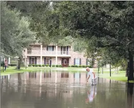  ?? SCOTT OLSON — GETTY IMAGES ?? A resident checks the depth of water as it continues to rise outside his Houston home. Twitter reported 21.2million tweets about Hurricane Harvey since Friday.