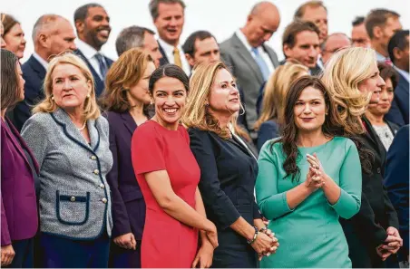  ?? Melina Mara / Washington Post ?? Alexandria Ocasio-Cortez, in red, joins other congressio­nal freshmen in the 116th class on the steps of the U.S. Capitol.
