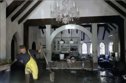  ?? THE ASSOCIATED PRESS ?? Bill Asher walks through mud in his home damaged by storms in Montecito, Calif., on Thursday. Rescue workers slogged through knee-deep ooze and used long poles to probe for bodies Thursday as the search dragged on for victims of the mudslides that...