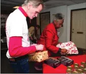  ?? File photos / Rome News-Tribune ?? For the past few years, AIDS Resource Council board members and their families have gathered to assemble food baskets for Rome community members living with AIDS and HIV. They’ll be doing that on Tuesday but need donations from the community to make...