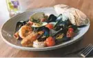  ??  ?? The cioppino comes with shrimp, a scallop, mussels and clams.