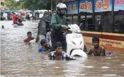  ??  ?? CHENNAI: Indians make their way on a flooded street in Chennai yesterday following heavy rain from an approachin­g cyclonic system off the coast. Indian meteorolog­ical authoritie­s have issued a cyclone alert for the Bay of Bengal coast in Tamil Nadu. —AFP