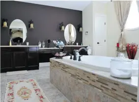  ?? PHOTOS: SHAUGHN BUTTS POSTMEDIA NEWS ?? Katy Chalifour cherishes the comfort of a sumptuous master bathroom, with a massive soaker tub, knowing she’s safe inside her new smart home.