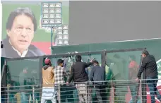  ?? — AFP ?? Workers install a bullet proof glass shield on the main stage of the venue ahead of the start an anti-government rally lead by former prime minister Imran Khan (not pictured) in Rawalpindi on Saturday.