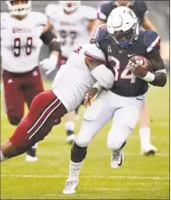  ?? Jessica Hill / Associated Press ?? UConn running back Kevin Mensah takes a hit from UMass safety Brice McAllister on Saturday.