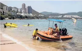  ?? ISAAC LAWRENCE/GETTY-AFP ?? Lifeguards in Hong Kong work Thursday after some COVID-19 restrictio­ns were relaxed. Among them included the reopening of beaches and pools.