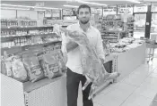  ??  ?? AlaaYousef, the ownerof theApna Bazaar, displays a 25-pound goat inside his store at the shopping center.